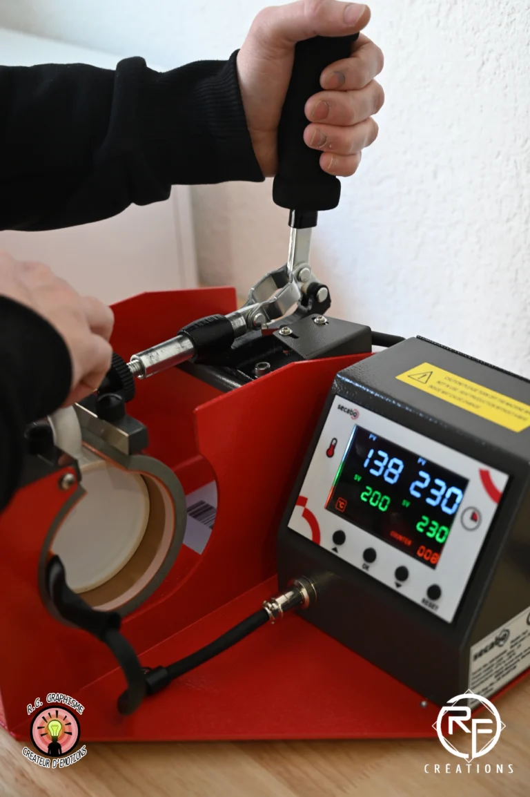 Machine de sublimation en cours d'impression sur un mug dans le studio de création RG Graphisme à Lunéville.